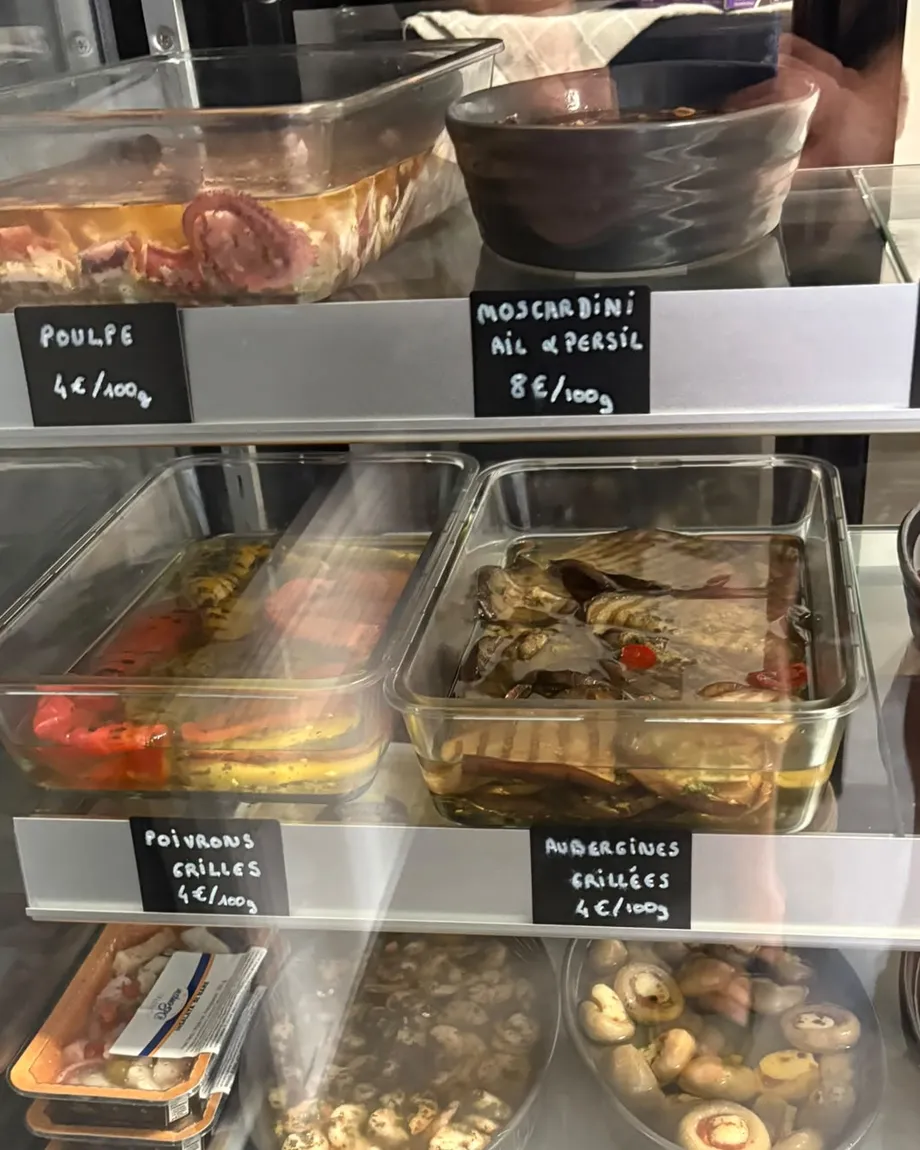 Antipasti au poids en vitrine : poulpe, moscardini, poivrons et aubergines grillées