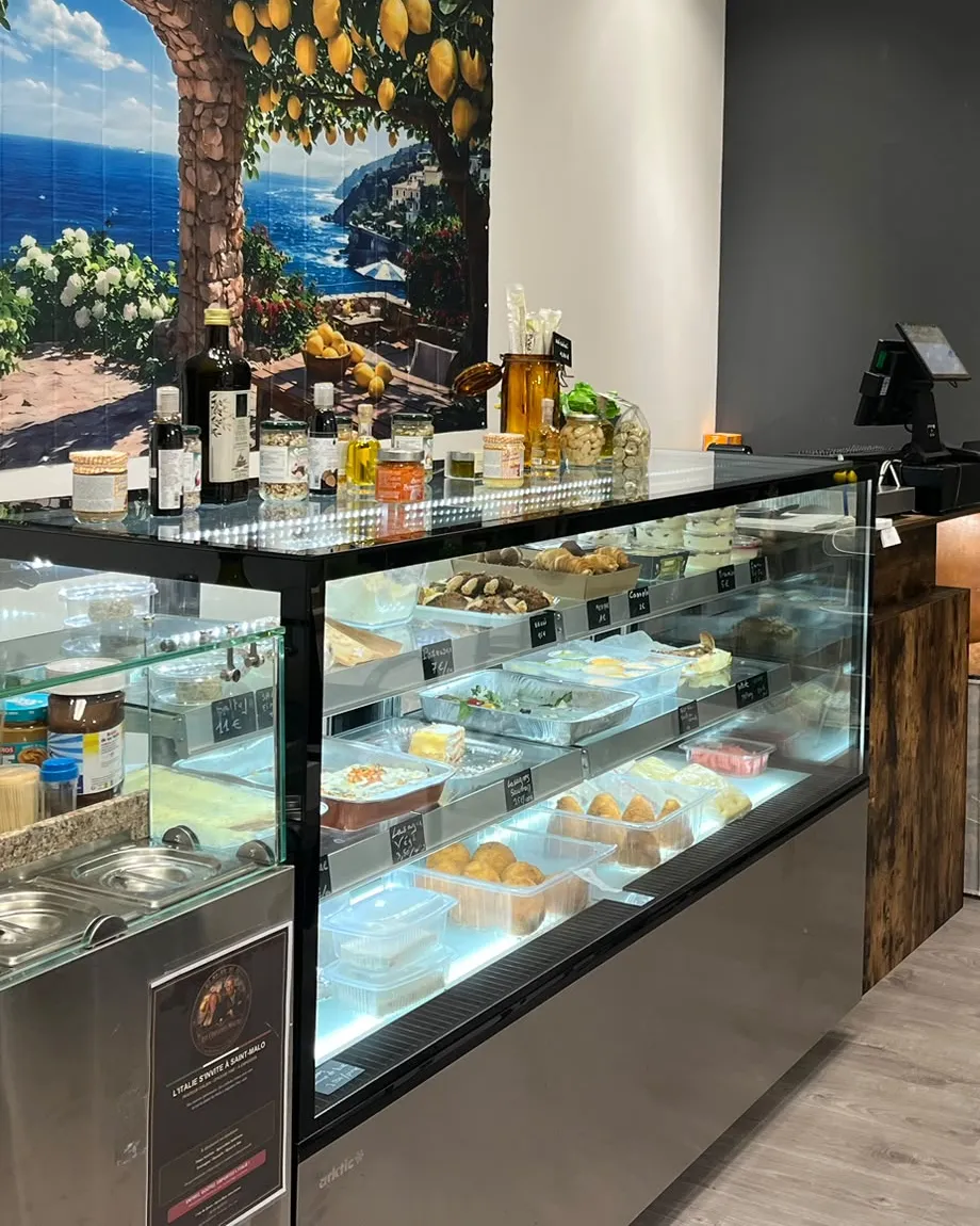 Le comptoir et sa vitrine, devant la fresque de la côte amalfitaine